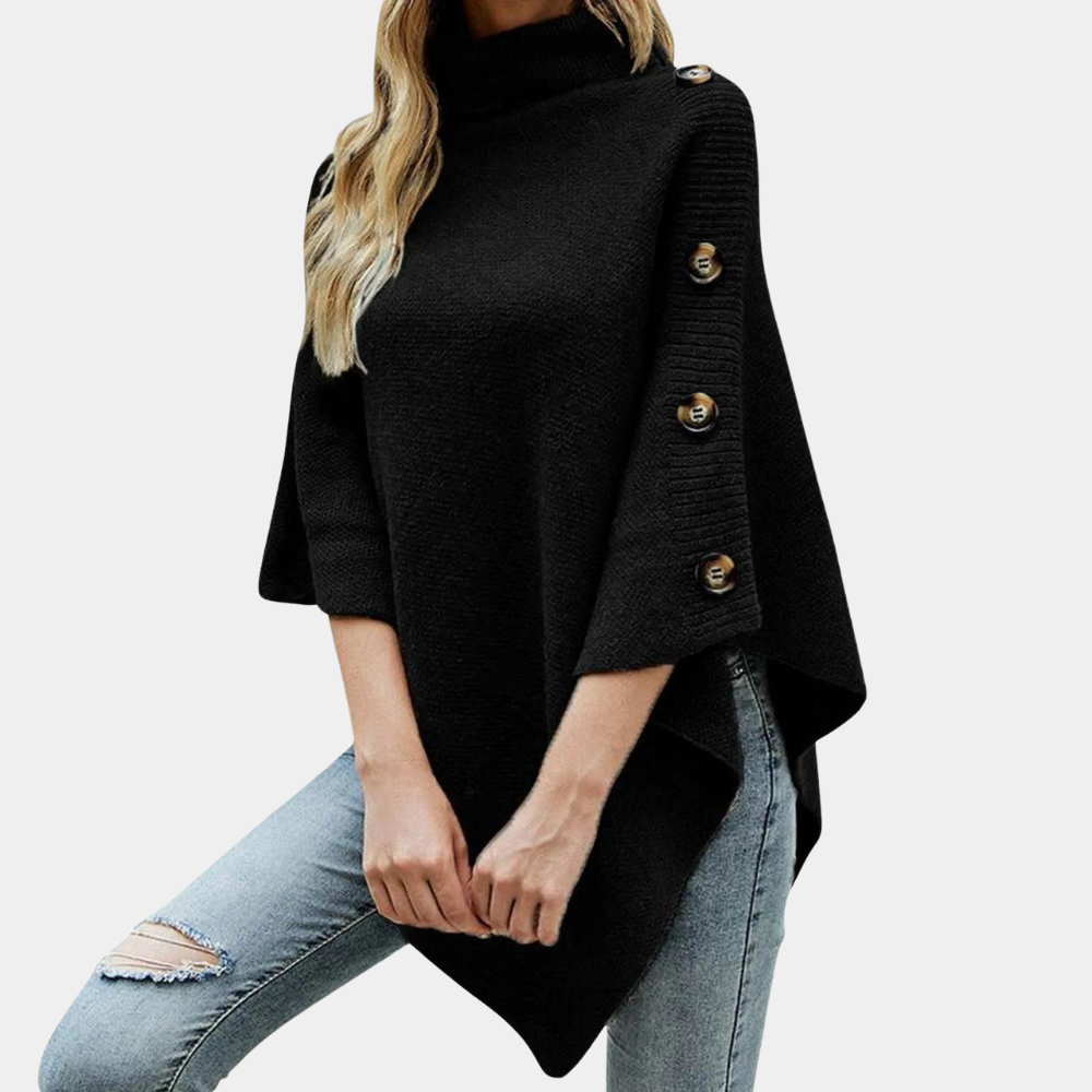 Zwarte poncho met knopen, driekwart mouwen en col, gedragen door model in blauwe jeans. Stijlvolle damesmode, herfstkleding, casual chic.