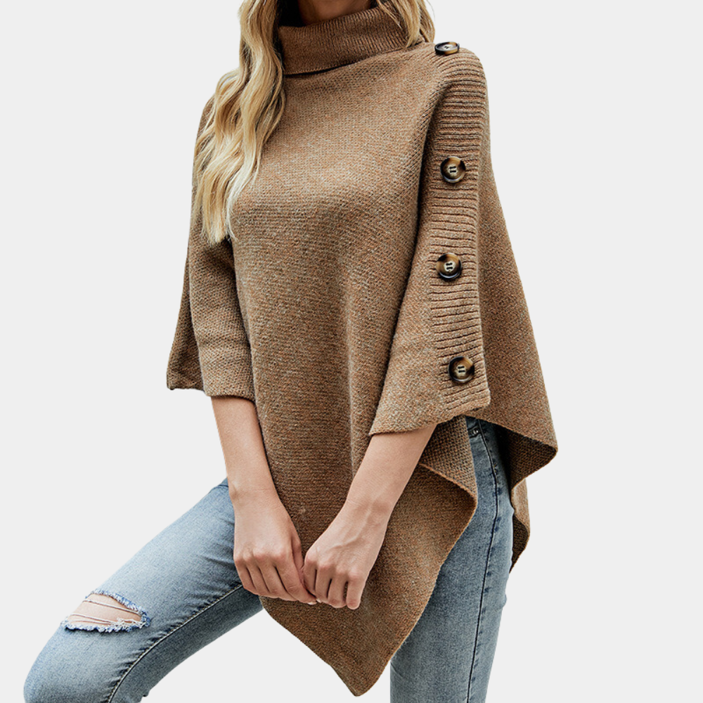 Vrouw in khaki poncho met knopen, gecombineerd met blauwe jeans. Modieuze herfstkleding, comfortabele damestrui, casual stijl.