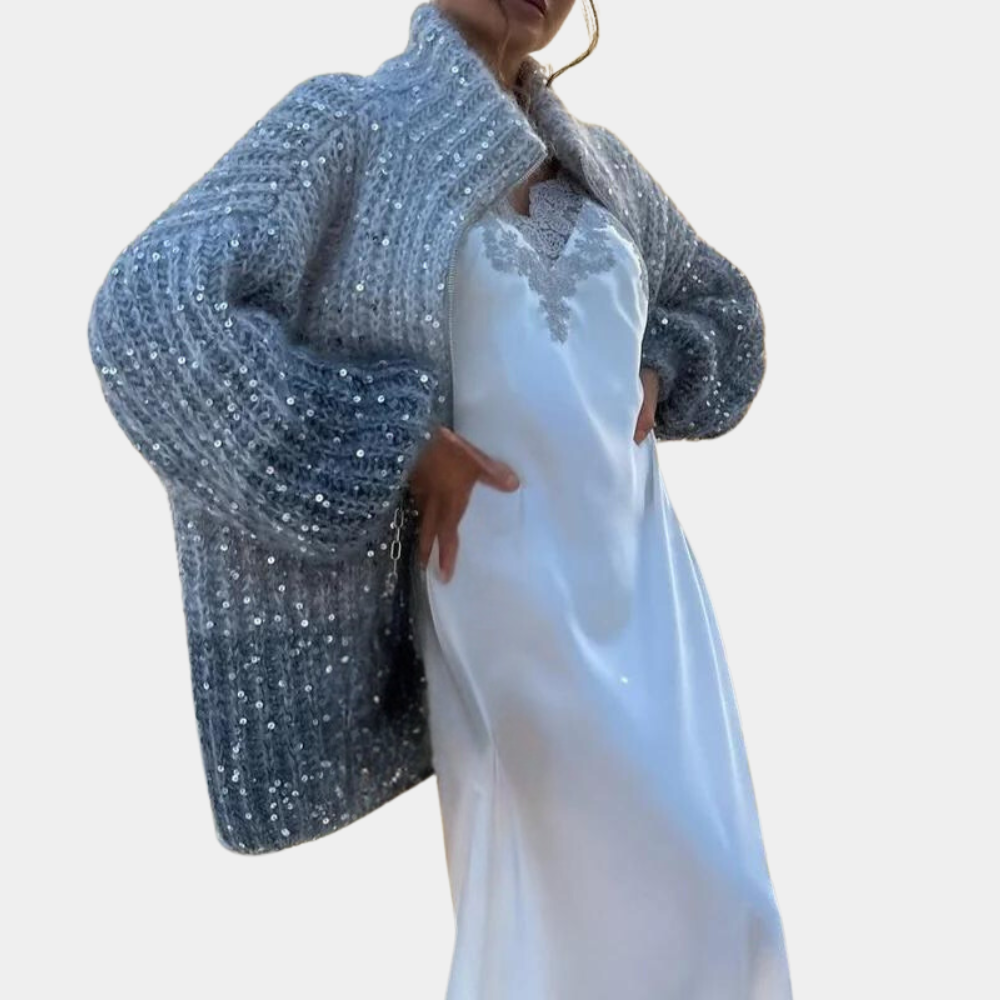 Vrouw in elegante witte jurk met blauwe, gebreide paillettenjas. Modieuze dameskleding, winterstijl, trendy outfit voor speciale gelegenheden.