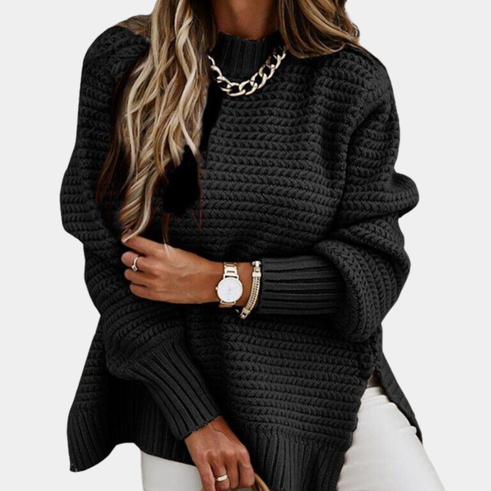 Zwarte gebreide trui met lange mouwen, gedragen door vrouw met horloge en armband. Modieuze dameskleding, herfst-winter stijl.