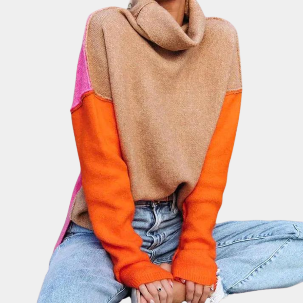 Vrouw draagt een kleurrijke trui met oranje en roze accenten, gecombineerd met een casual blauwe spijkerbroek. Modieuze herfstkleding, trendy outfit.