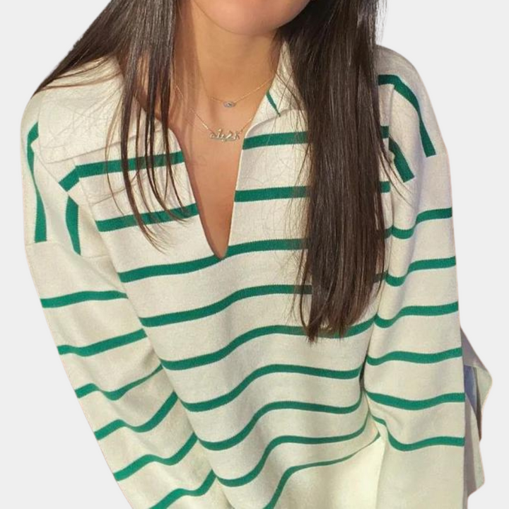 Vrouw in beige trui met groene strepen, V-hals en lange mouwen. Modieuze dameskleding, casual stijl, trendy outfit voor dagelijks gebruik.