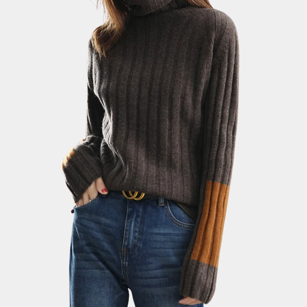 Bruine geribbelde trui met col en oranje mouwaccenten, gedragen door model in blauwe jeans. Stijlvolle damesmode, herfstkleding, casual outfit.