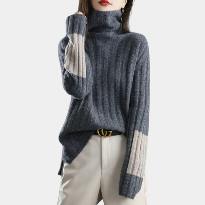 Grijze geribbelde coltrui met beige accenten op de mouwen, gedragen door een model. Stijlvolle damesmode, herfst-winter kleding, casual chic.