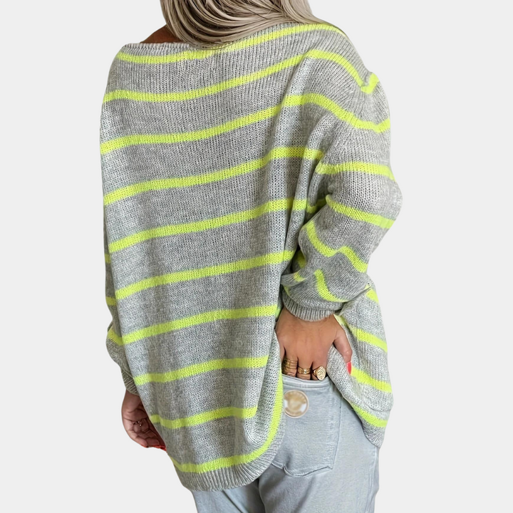 Grijze trui met gele strepen, gedragen door vrouw. Modieuze oversized pasvorm, casual stijl. Perfect voor herfst- en wintermode.