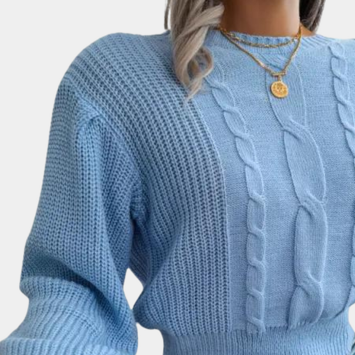 Blauwe gebreide damestrui met kabelpatroon, lange mouwen en ronde hals. Modieuze winterkleding, comfortabel en stijlvol.