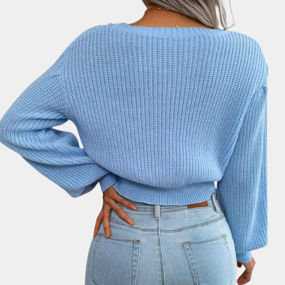 Vrouw in lichtblauwe gebreide trui en spijkerbroek, rugaanzicht. Modieuze dameskleding, casual stijl, herfst-winter outfit.