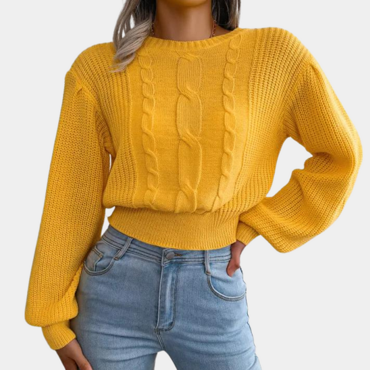 Vrouw in gele kabeltrui met lange mouwen en blauwe jeans. Modieuze dameskleding, herfstoutfit, casual stijl.