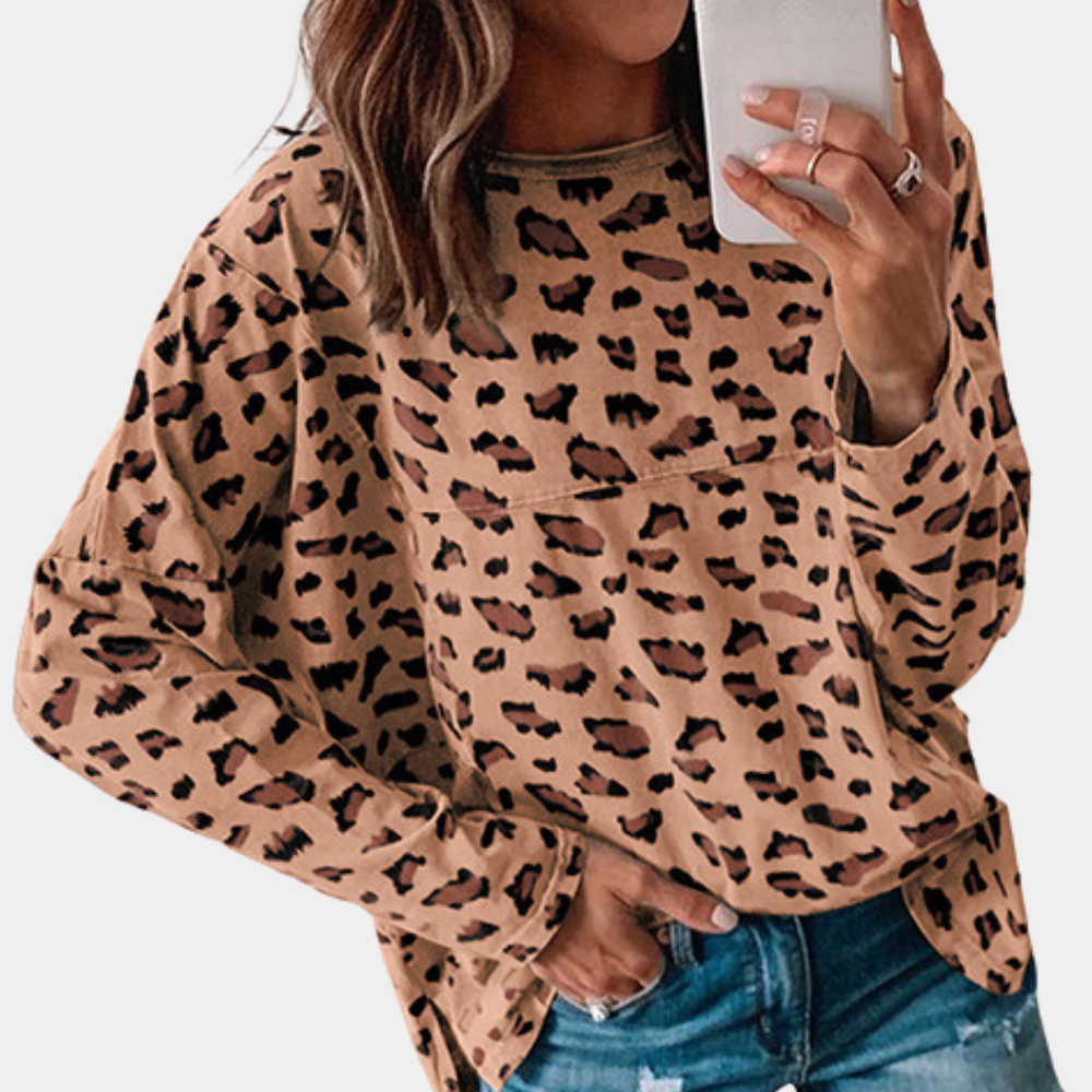 Vrouw in bruine luipaardprint trui, casual mode, trendy herfstkleding, smartphone in hand, denim jeans, stijlvolle damesoutfit.