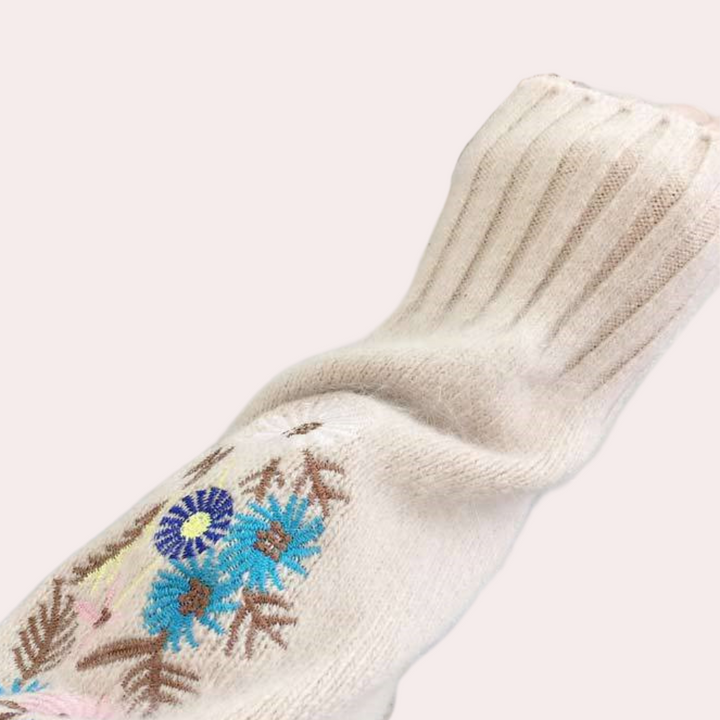 Beige gebreide trui met kleurrijk bloemenborduursel, lange mouw, ribgebreide manchetten. Modieuze dameskleding, herfst-winter stijl.