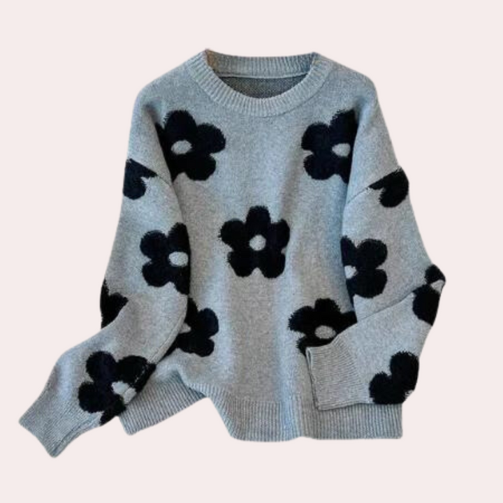 Grijze trui met zwarte bloemenprint, ronde hals en lange mouwen. Modieuze dameskleding, ideaal voor herfst en winter. Comfortabel en stijlvol.