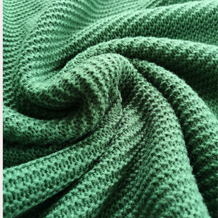 Groene gebreide stof close-up, zachte textuur, geschikt voor kleding en interieur. Perfect voor modeontwerp en huisdecoratie.