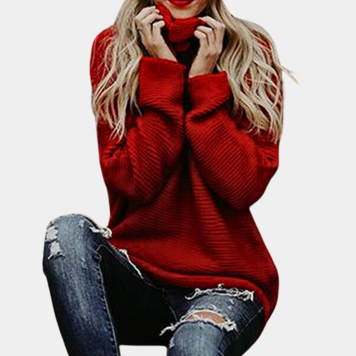 Vrouw in rode trui met col, zittend in gescheurde jeans. Modieuze dameskleding, herfst- en winterstijl, casual en comfortabel.