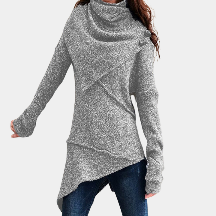 Grijze asymmetrische damestrui met lange mouwen, gemaakt van zachte stof. Perfect voor casual herfst- en winteroutfits. Comfortabele en stijlvolle pasvorm.