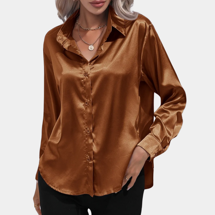 Vrouw in glanzende, donkerbruine satijnen blouse met lange mouwen en knoopsluiting, stijlvolle mode, elegante dameskleding.