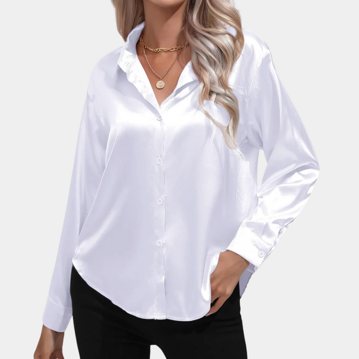 Witte satijnen blouse voor dames met lange mouwen en knoopsluiting, gedragen door model. Perfect voor elegante en zakelijke outfits.