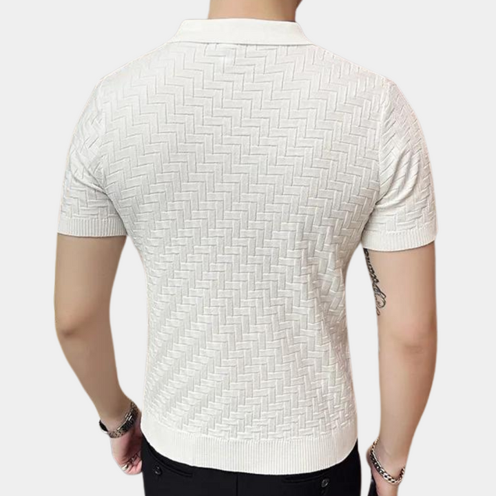 Witte herenpolo met korte mouwen, zigzagpatroon, gedragen door man. Stijlvolle casual kleding, geschikt voor zomer en lente.