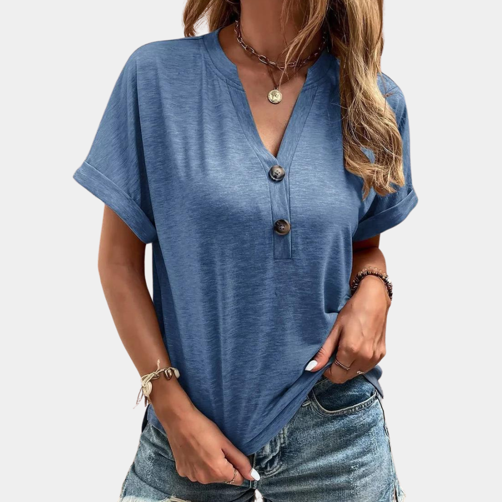 Blauwe dames T-shirt met korte mouwen, V-hals en knoopsluiting, gedragen met spijkerbroek. Perfect voor casual zomeroutfits.