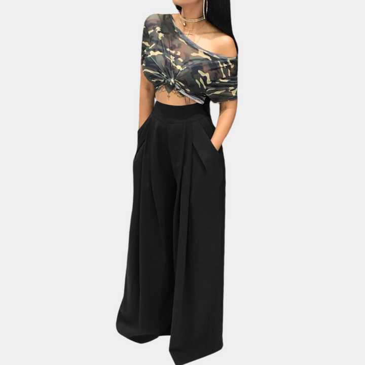 Vrouw in zwarte wijde broek en camouflage off-shoulder top, modieuze dameskleding, trendy outfit, casual chique stijl, modeaccessoires.