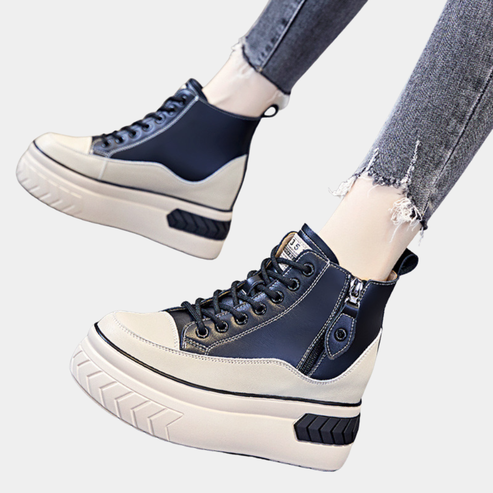 Zwarte en witte platform sneakers met dikke zool, rits en veters, gedragen met gescheurde jeans. Trendy damesschoenen, casual stijl.