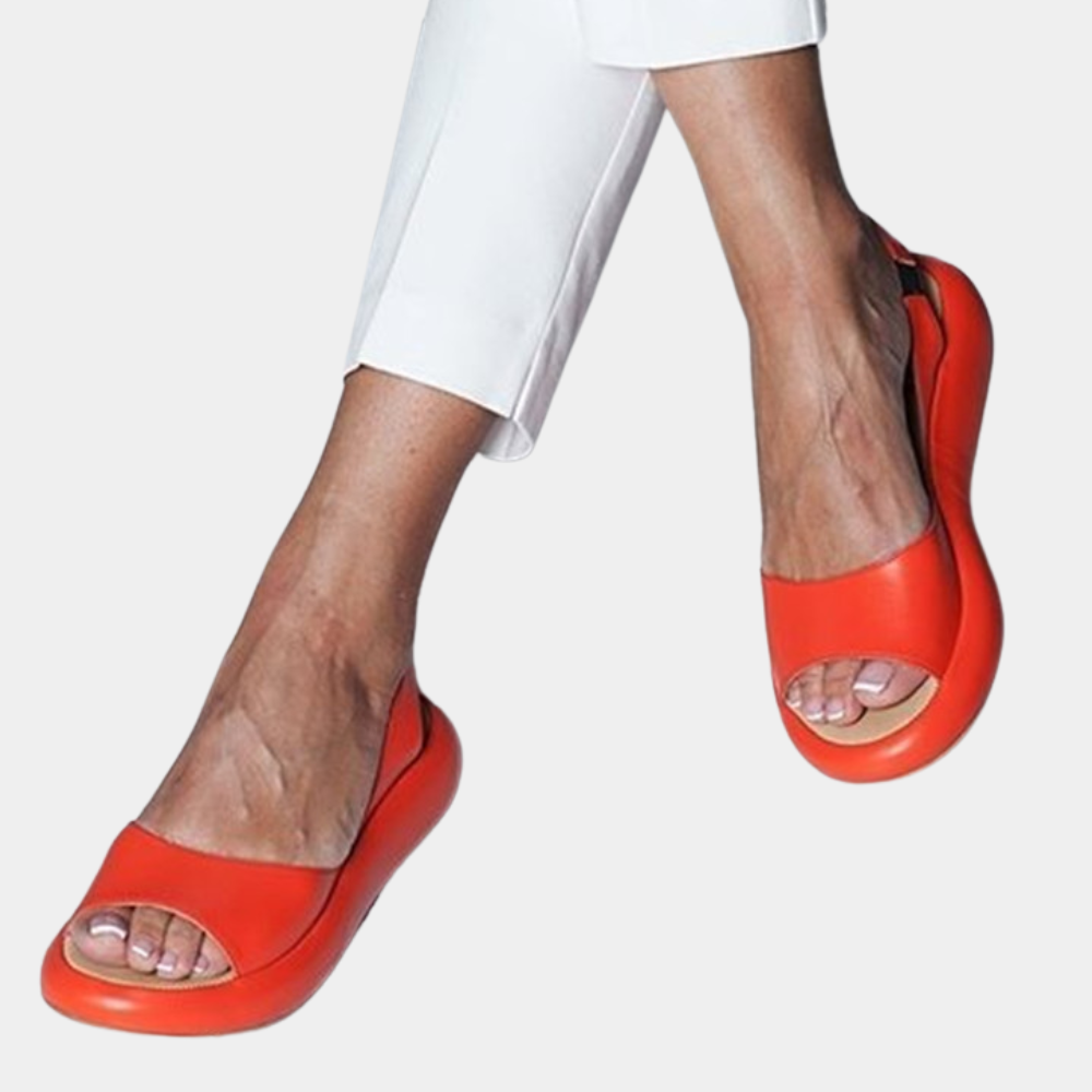 Oranje sandalen met open teen, gedragen door een persoon in witte broek. Stijlvolle zomerschoenen, comfortabel en modieus voor dagelijks gebruik.