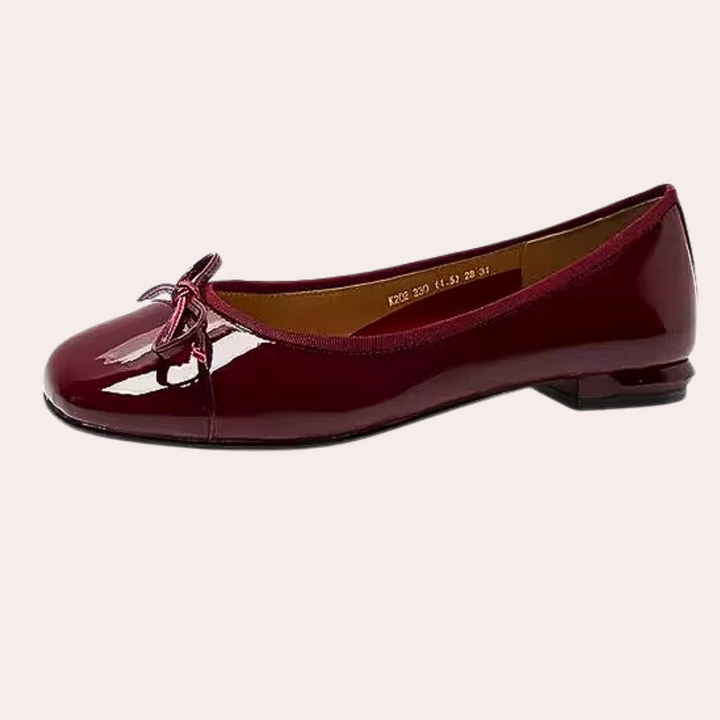 Bordeauxrode ballerina met strik, glanzend lakleer, platte zool. Stijlvolle damesschoen, perfect voor casual en formele gelegenheden.