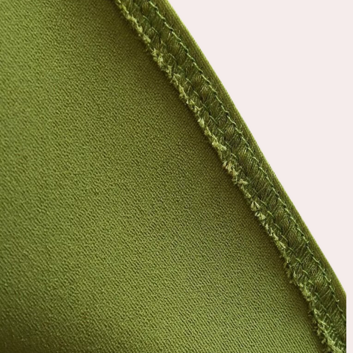 Groene stof close-up met zichtbare stiksels, textieltextuur, naad details. Perfect voor modeontwerp, kledingproductie, duurzame stoffen.