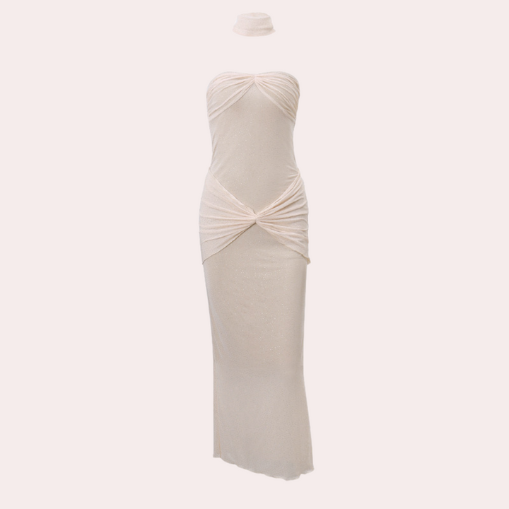 Strapless apricotkleurige jurk met gedrapeerde details, elegante lange snit en bijpassende choker. Perfect voor avondkleding en speciale gelegenheden.