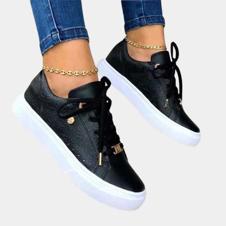 Zwarte damessneakers met witte zool, gouden details en bloemenpatroon. Modieuze casual schoenen, perfect voor dagelijks gebruik en comfort.