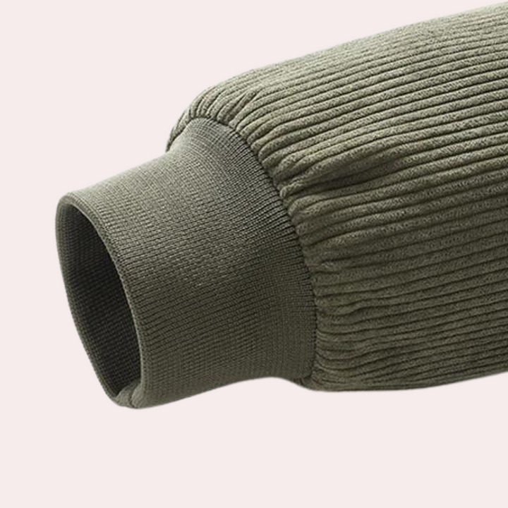 Olijfgroene geribbelde mouw van een trui, close-up. Modieuze herenkleding, comfortabele pasvorm, trendy textuur, casual stijl.