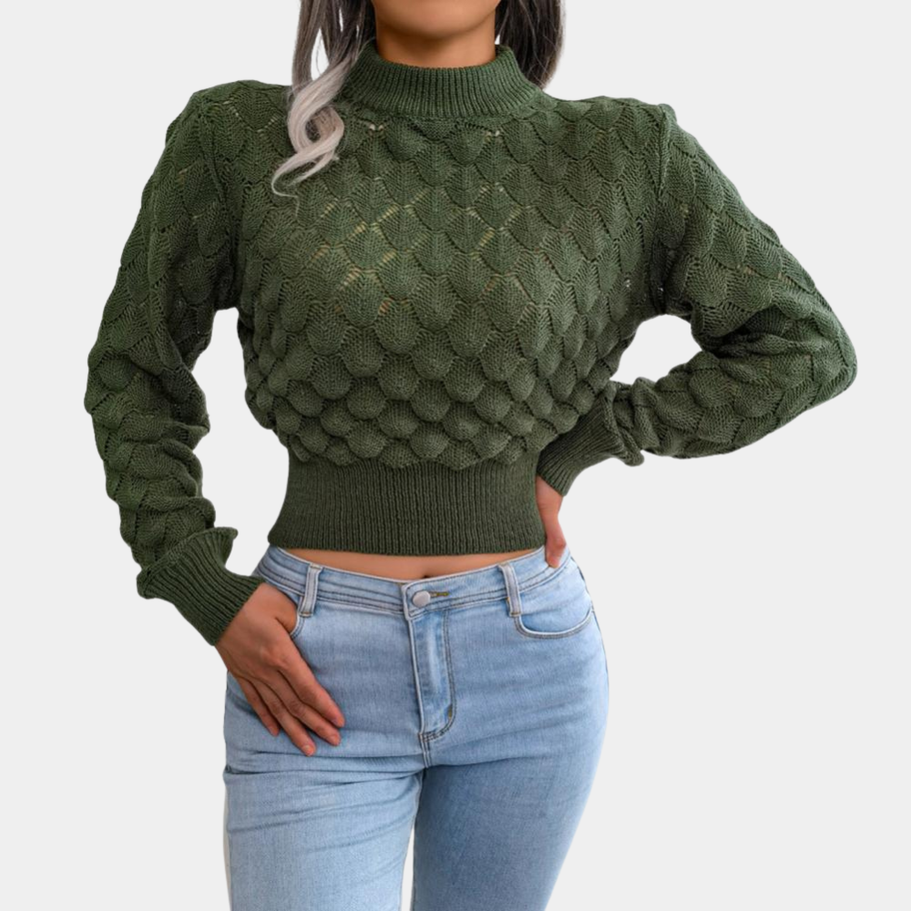 Groene gebreide trui met schubbenpatroon, lange mouwen en hoge hals, gedragen door model in blauwe jeans. Stijlvolle damesmode, herfstkleding.
