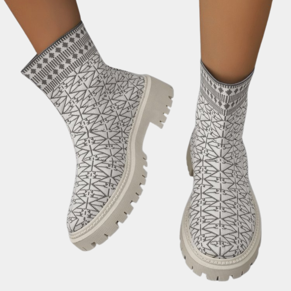 Witte enkellaarsjes met zwart geometrisch patroon, dikke zool en moderne stijl. Perfect voor modebewuste vrouwen. Comfortabele en trendy schoenen.