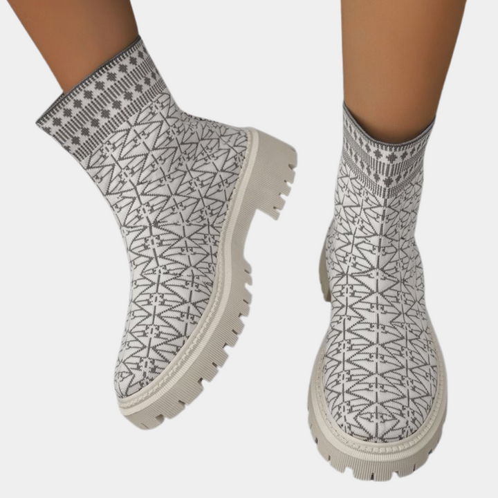 Witte enkellaarsjes met zwart geometrisch patroon, dikke zool en moderne stijl. Perfect voor modebewuste vrouwen. Comfortabele en trendy schoenen.