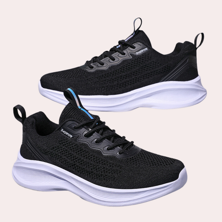 Zwarte sportschoenen met witte zool, ademend mesh bovenwerk, geschikt voor hardlopen en fitness. Stijlvol en comfortabel schoeisel voor dagelijks gebruik.