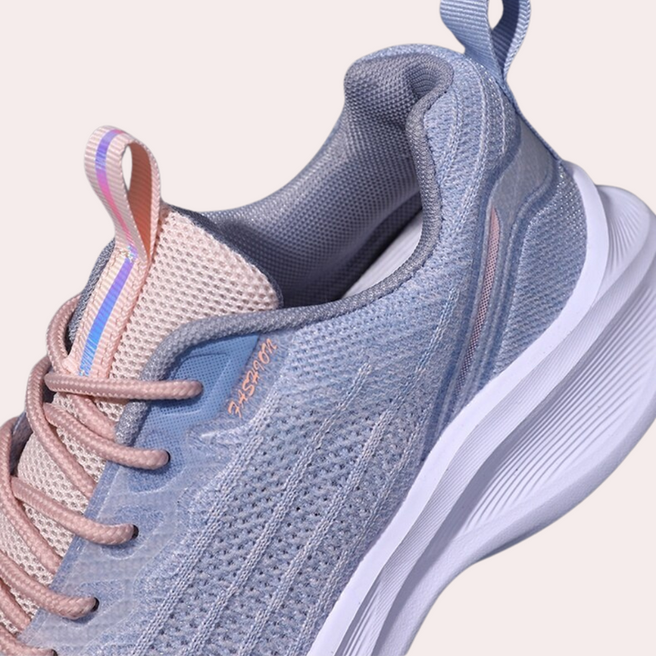 Grijze sportschoen met roze en blauwe accenten, ademend mesh bovenwerk, witte zool en lusdetail. Perfect voor hardlopen en casual gebruik.