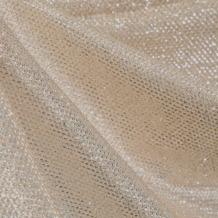Champagnekleurige glitterstof met glinsterende pailletten, ideaal voor feestelijke kleding en decoratie. Luxueuze textuur en sprankelende uitstraling.
