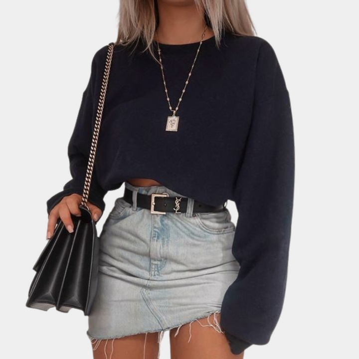 Vrouw in zwarte cropped trui, spijkerrok en zwarte tas. Modieuze outfit, casual stijl, trendy kleding. Perfect voor dagelijks gebruik.