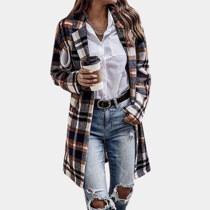 Vrouw in geruite khaki jas, witte blouse en gescheurde jeans, houdt koffiebeker vast. Modieuze herfstoutfit, casual dameskleding.