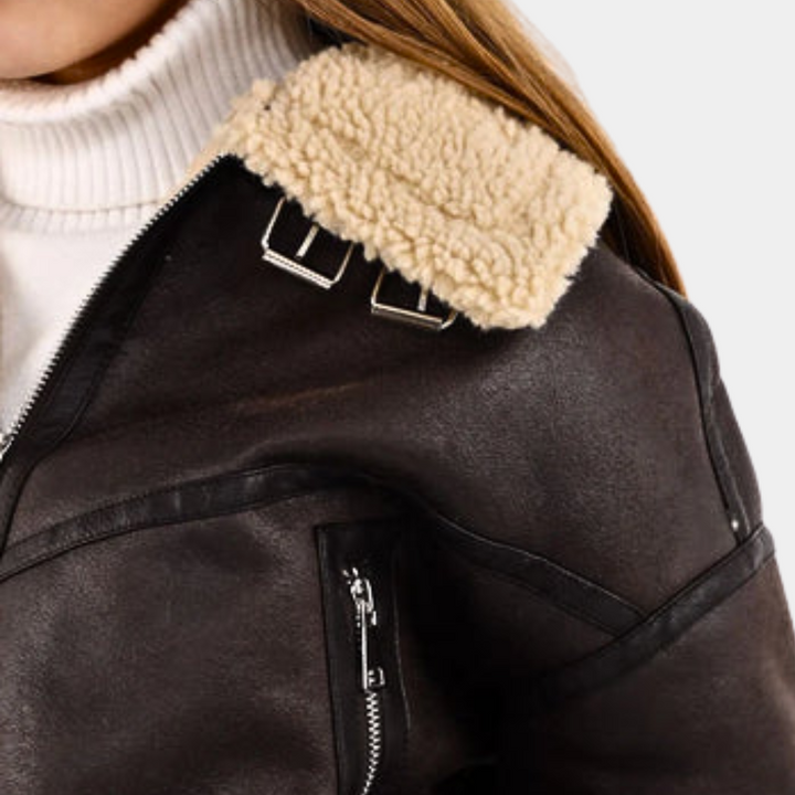 Bruine leren jas met schapenvacht kraag, ritsdetails en gesp, gedragen door vrouw. Modieuze winterjas, warme dameskleding, stijlvol design.