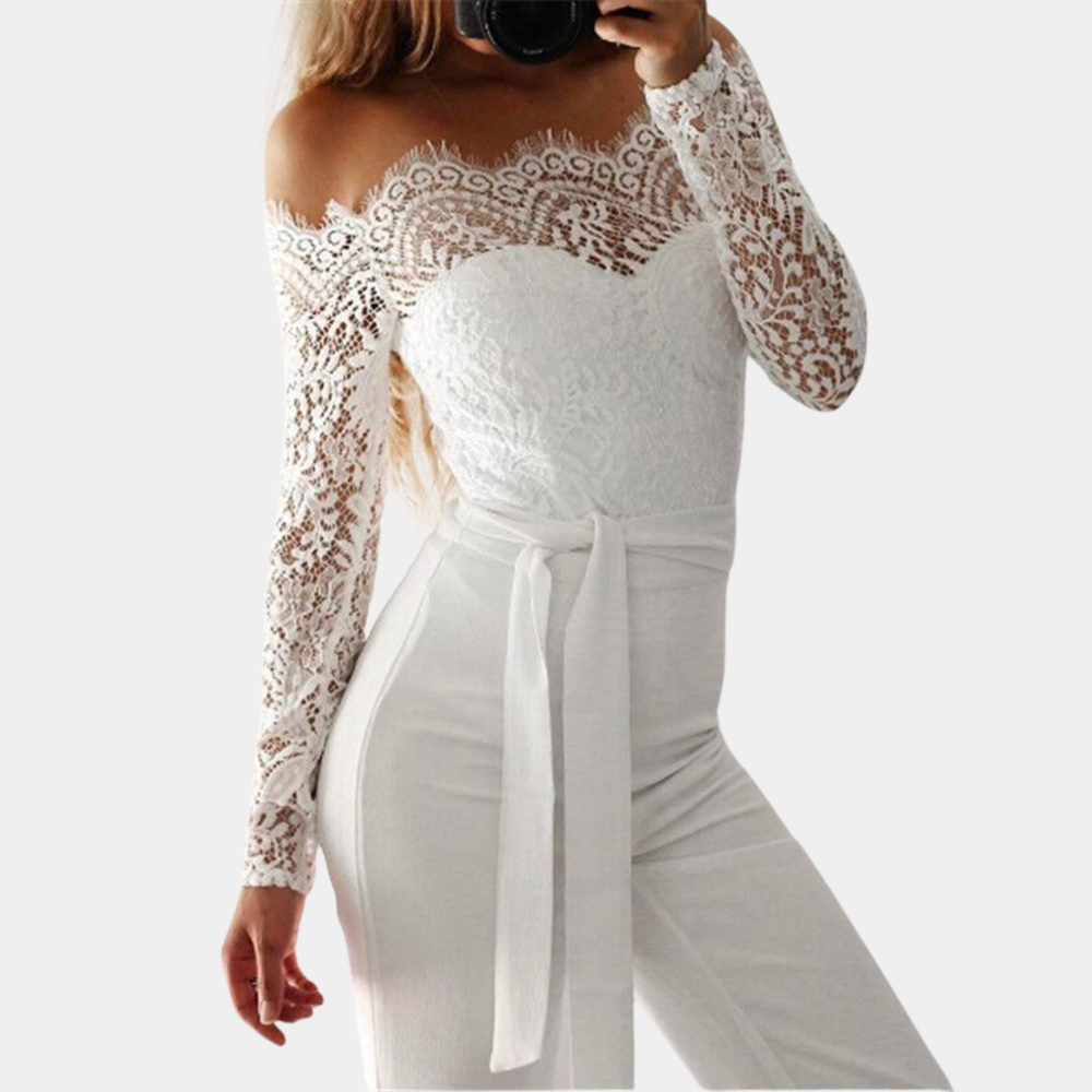 Vrouw in elegante witte kanten jumpsuit met lange mouwen en strikceintuur, modieuze dameskleding, stijlvolle outfit voor speciale gelegenheden.