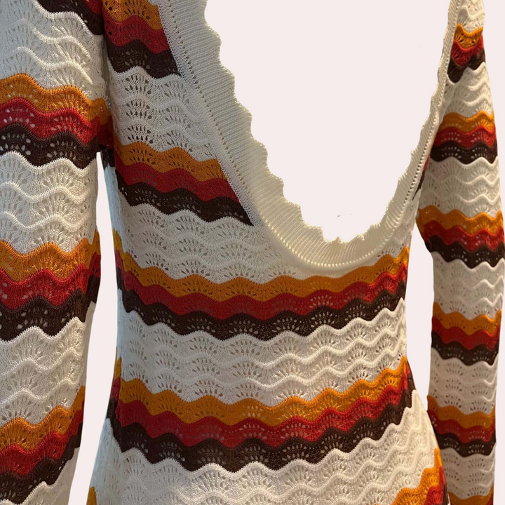 Retro gebreide trui met golvende strepen in wit, oranje, rood en bruin. Vintage stijl, damesmode, herfstkleding, unieke patronen.