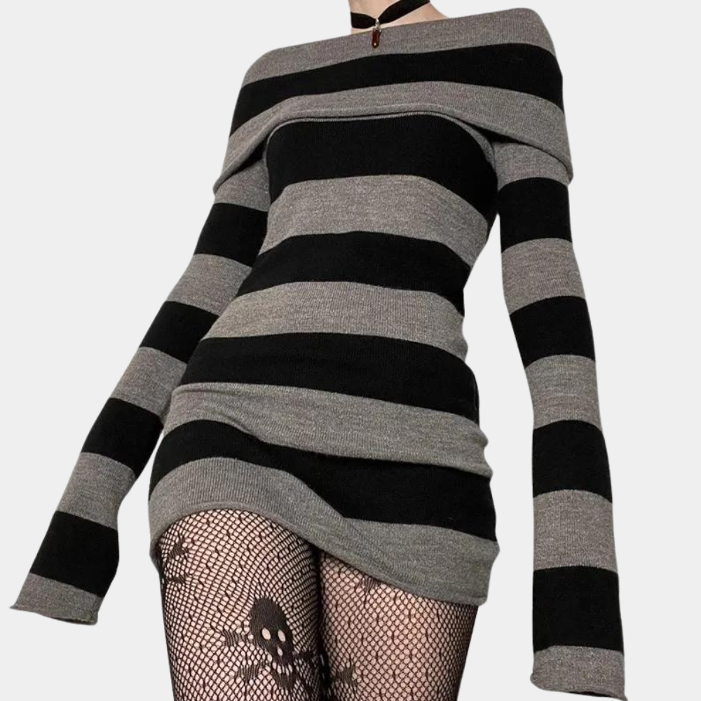 Zwart-grijs gestreepte trui jurk met lange mouwen, gecombineerd met visnetpanty met schedelontwerp. Trendy damesmode, alternatieve stijl.