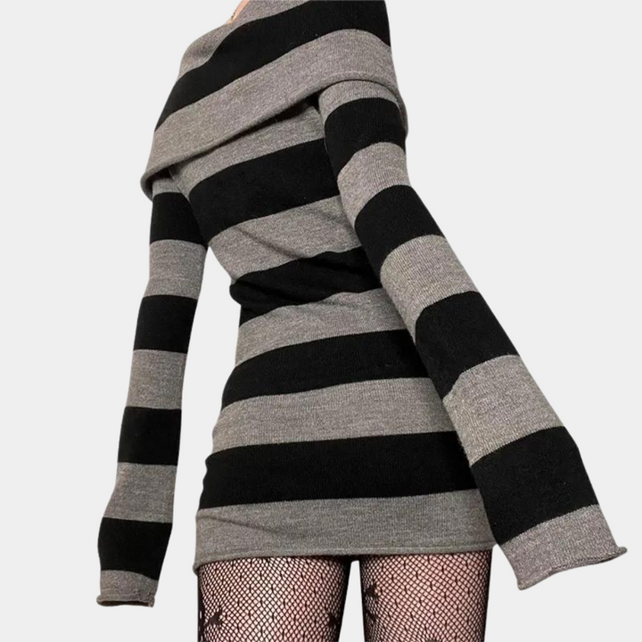 Zwart-grijs gestreepte trui jurk met lange mouwen, gedragen met visnetpanty. Modieuze dameskleding, herfst-winter stijl, trendy outfit.