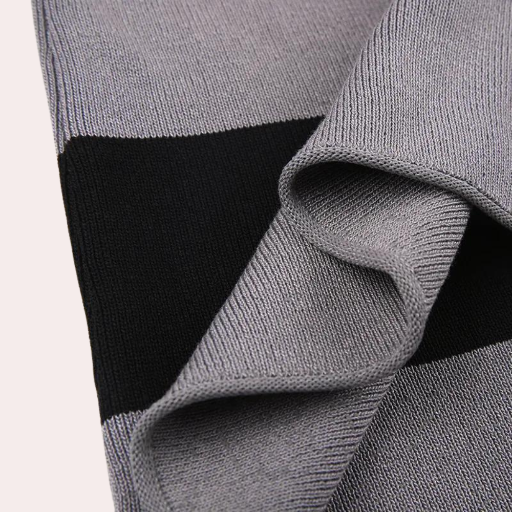 Grijze en zwarte gebreide sjaal, close-up textuur, modieuze winteraccessoire, zachte stof, geschikt voor heren en dames, trendy design.