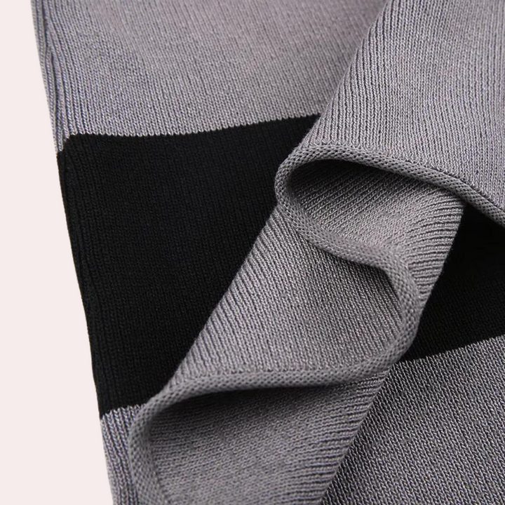 Grijze en zwarte gebreide sjaal, close-up textuur, modieuze winteraccessoire, zachte stof, geschikt voor heren en dames, trendy design.