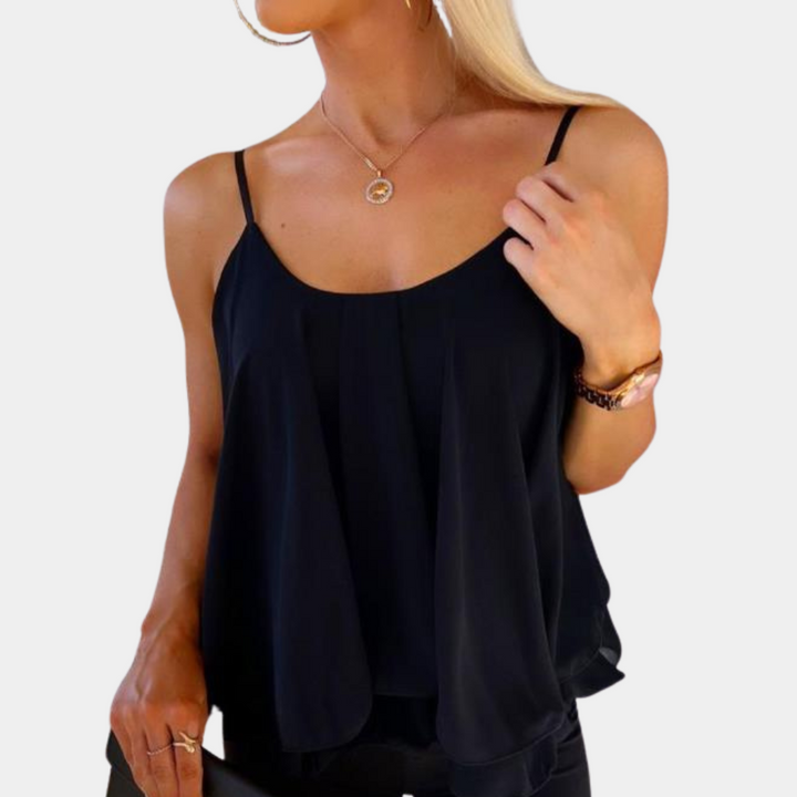 Vrouw in zwarte, mouwloze top met spaghettibandjes, gouden ketting en horloge. Modieuze dameskleding, elegante casual stijl.