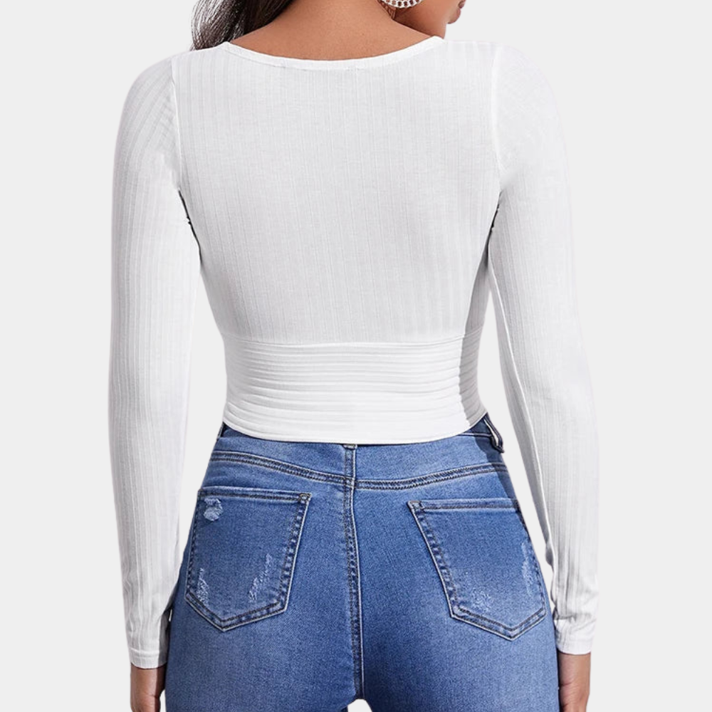 Witte ribgebreide dames top met lange mouwen, gecombineerd met blauwe jeans. Modieuze casual outfit, ideaal voor dagelijks gebruik.