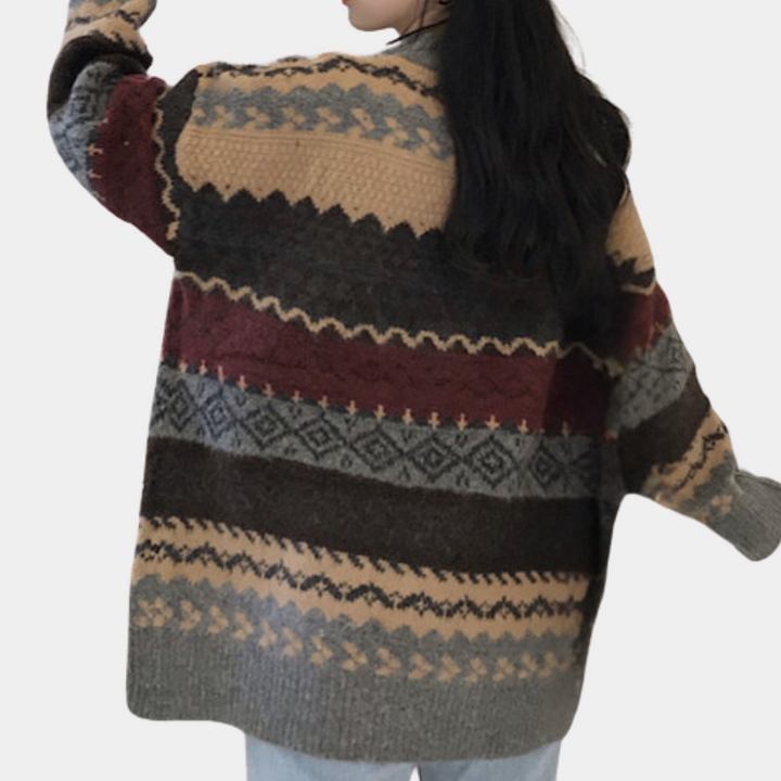 Grijze gebreide trui met kleurrijk zigzagpatroon, lange mouwen en ronde hals. Perfect voor herfstmode en casual winteroutfits.