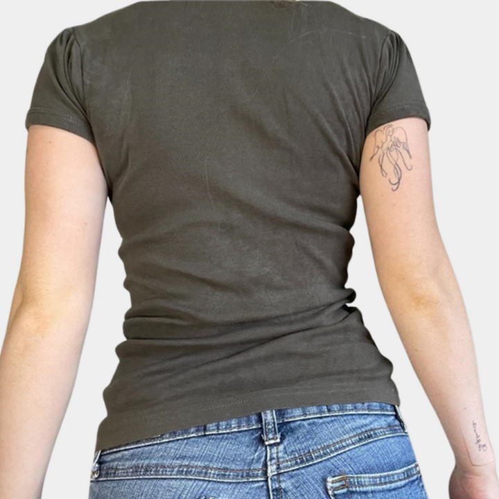 Grijze dames T-shirt met korte mouwen, gedragen door model, rugaanzicht. Casual mode, katoenen stof, tattoo op arm zichtbaar.
