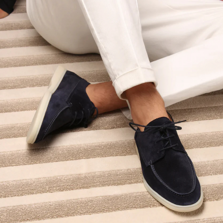 Donkerblauwe suède herenschoenen met veters, gedragen met witte broek. Stijlvolle casual schoenen voor heren, perfect voor dagelijks gebruik.